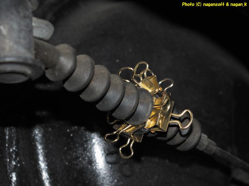 「なが～ン」所有車、クラウンワゴン GS130 1GFE、2025年11月23日、サイドブレーキワイヤーブーツの破箇所にボンドを塗って接着、仮固定に文具のクリップを用いる