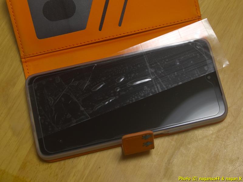 スマホの割れたガラスフィルムにテープを貼り付けて剥がす。2026年02月13日撮影