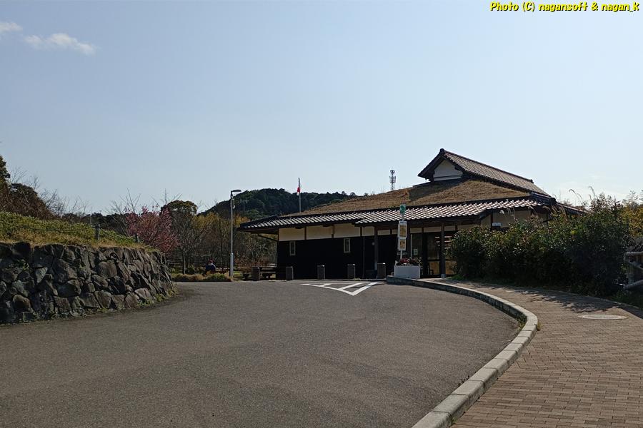 路面側から見る草屋根の「パークセンター」。大阪府・泉佐野丘陵緑地、2026年03月15日撮影