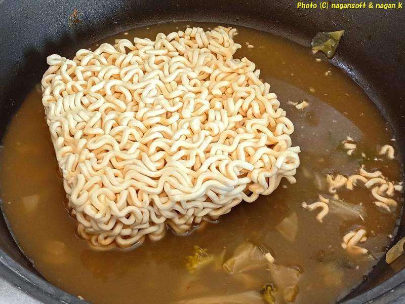 「ヤムヤムトムヤムクンヌードル」のインスタント麺を投入。2026年03月17日撮影