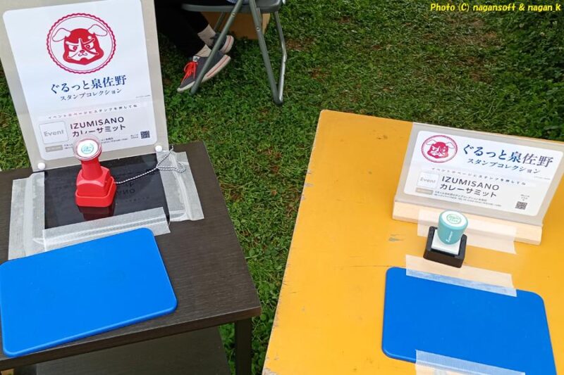 「いずみさのカレーサミット2026」イベント会場内の、「ぐるっと泉佐野スタンプコレクション」押印台とスタンプ。来場者多数を見込んんでか複数のスタンプが設置されている。そのうちにスタンプ台２個を撮影｜大阪府泉佐野市｜2026年05月31日撮影