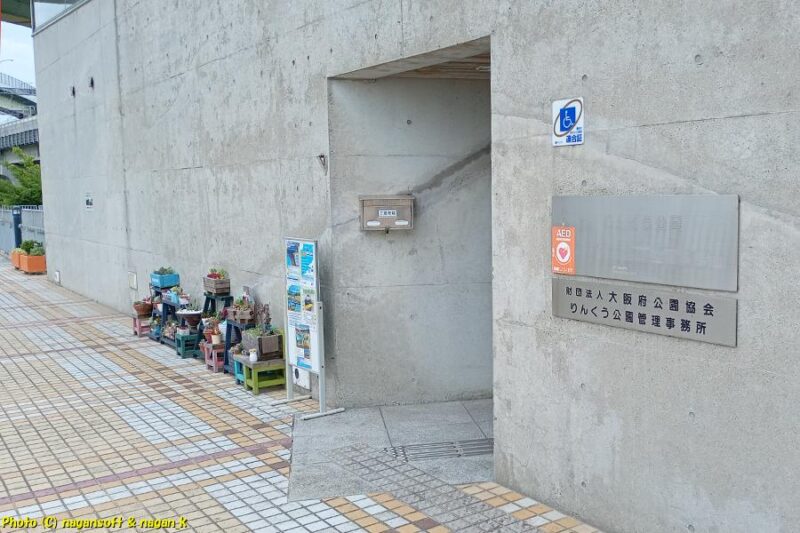 「いずみさのカレーサミット2026」イベント会場内横にある、“りんくう公園管理事務所”の入り口。コンクリート建屋にぽっかりと入り口が作られている｜大阪府泉佐野市｜2026年05月31日撮影